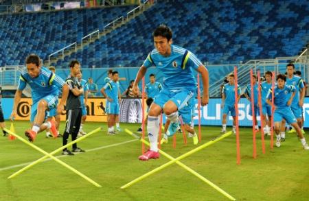 障害を飛び越えダッシュする長谷部誠（手前右）と長友佑都（同左）ら日本代表＝ブラジル・ナタルのドゥナス競技場（撮影・吉澤敬太）