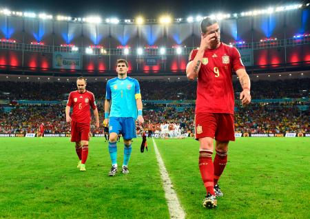 　チリに敗れて１次リーグ敗退が決まり、肩を落とし引き揚げるスペインの（右から）フェルナンドトレス、ＧＫカシリャス、イニエスタ。中央奥は勝利を喜ぶチリイレブン（ゲッティ＝共同）