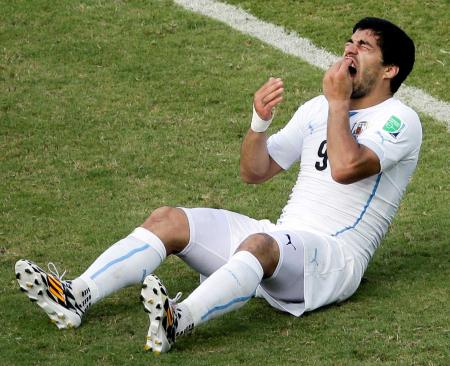 　後半、イタリアのキエリーニと交錯し、痛がるウルグアイのスアレス。肩にかみついた疑いがある（ＡＰ＝共同）