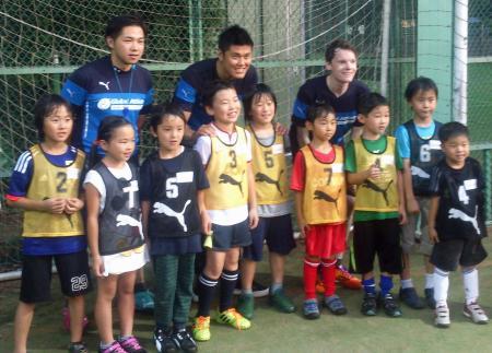 　自身がアンバサダーを務めるサッカースクールで、子どもたちと記念写真に納まるサッカー日本代表のＧＫ川島（後列中央）＝１１日、東京都新宿区