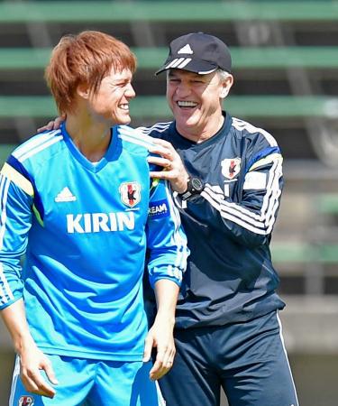 　練習で失敗した酒井高（左）の肩を抱き、笑顔で励ますアギーレ監督（撮影・吉澤敬太）