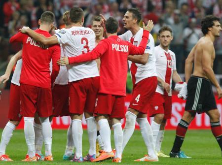 　勝利を喜ぶポーランドの選手と引き揚げるドイツのフンメルス（右端）＝ワルシャワ（ＡＰ＝共同）