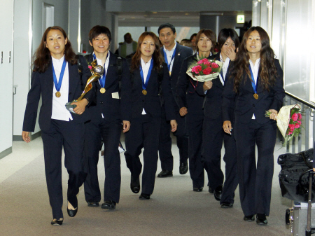 　ドイツＷ杯で優勝し、優勝杯を手に帰国した山郷（左）＝２０１１年７月１９日、成田空港