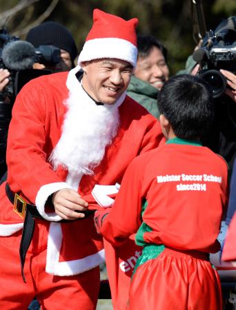 　サンタクロースに扮し、子どもにプレゼントを渡すマインツの岡崎
