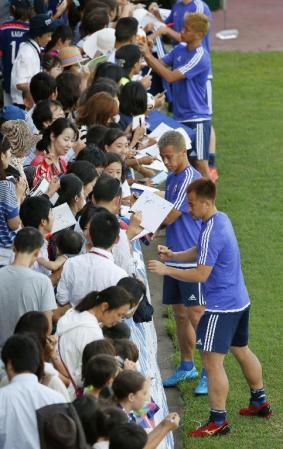 　練習を終え、集まった地元の邦人らにサインする（手前から）岡崎、本田ら