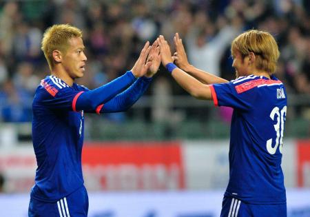 　後半、追加点となるゴールを決め、宇佐美貴史（右）とハイタッチする本田