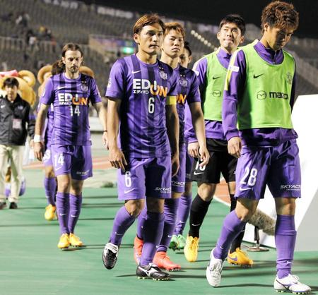 　うな垂れながらスタンドのファンにあいさつに向かう広島・青山（中央）ら広島イレブン