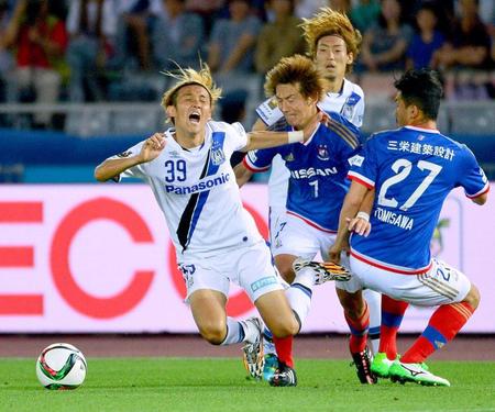 　後半、激しいマークで倒されるＧ大阪・宇佐美（左）。このファウルで得たＦＫが同点ゴールにつながった