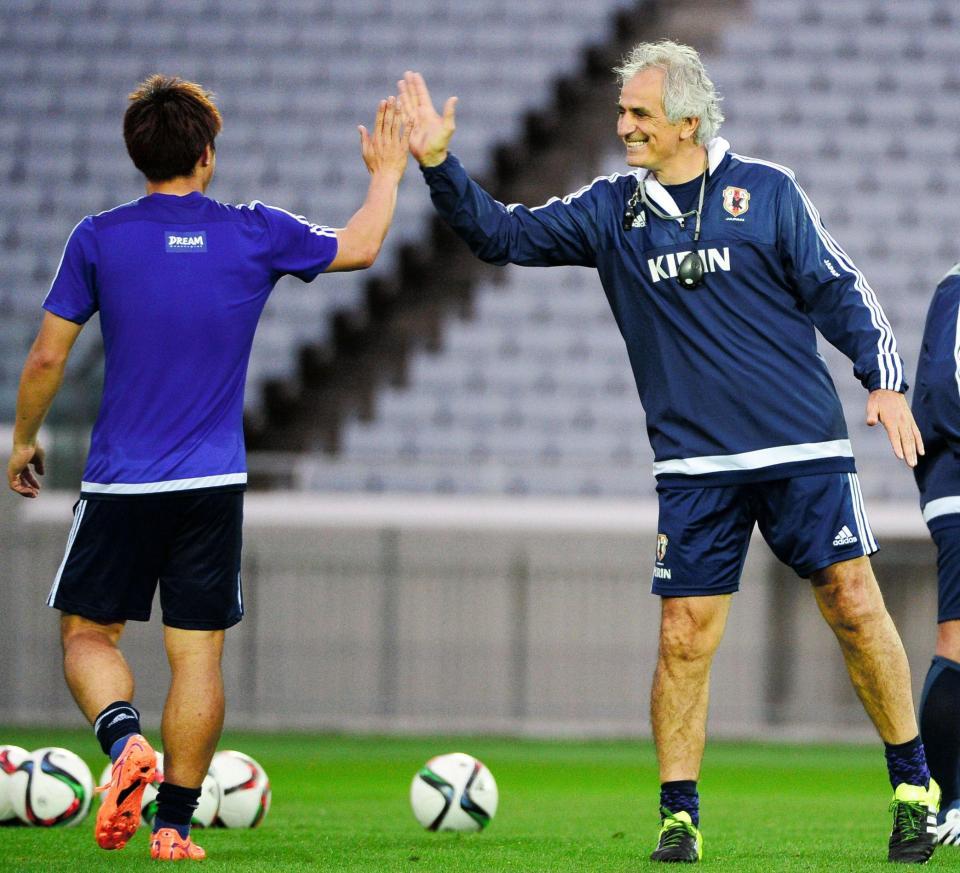 　岡崎とハイタッチする日本代表・ハリルホジッチ監督（右）＝横浜市内の練習場（撮影・三好信也）