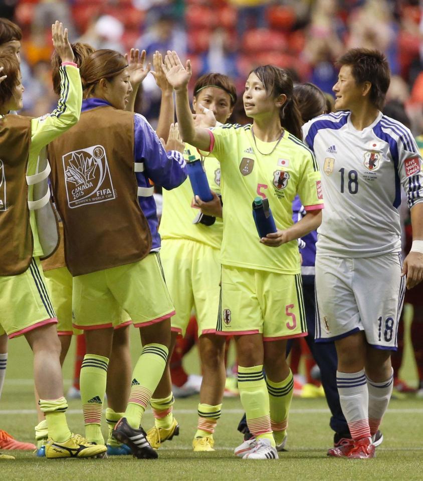 　サッカー女子Ｗ杯１次リーグ第２戦でカメルーンを下し、決勝トーナメント進出を決めハイタッチする鮫島（右から２人目）ら日本イレブン＝12日、カナダ・バンクーバー（共同）