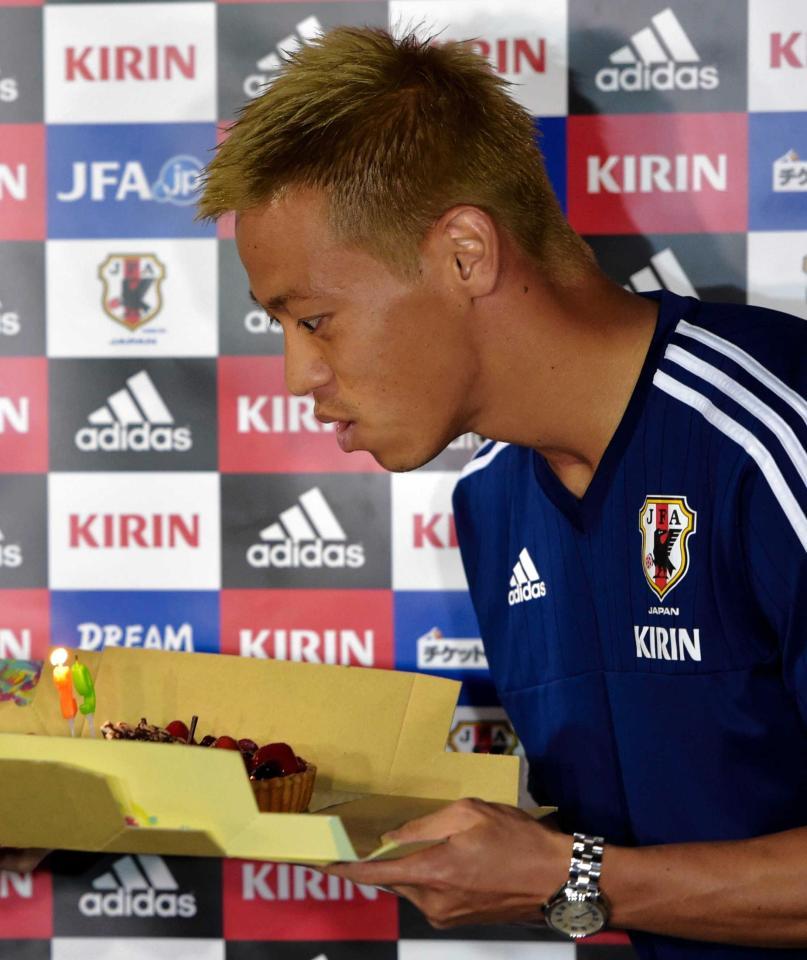 　報道陣から贈られたバースデーケーキのろうそくを吹き消す本田