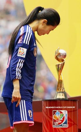 　表彰に向かう澤。右は優勝した米国に贈られるトロフィー＝バンクーバー（共同）