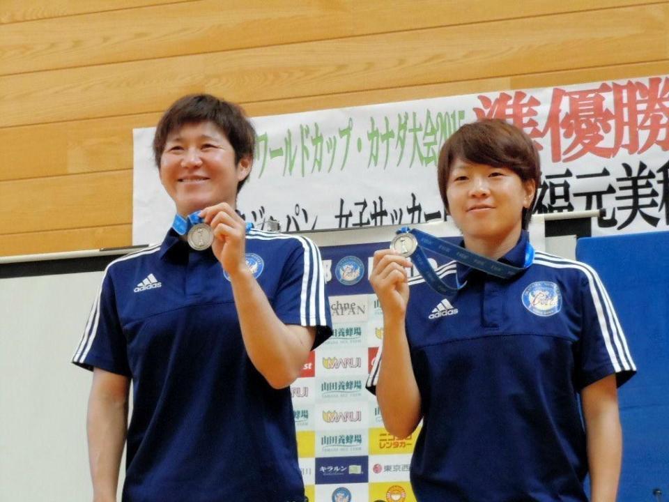 銀メダルを掲げて笑顔を見せる宮間（右）と福元
