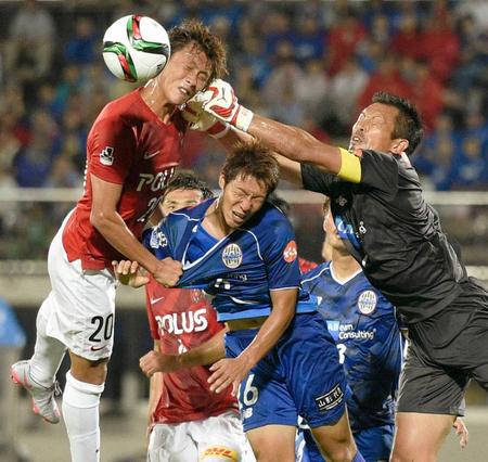 　前半、ゴール前に飛び込む浦和・李（左）と防ぐ山形・ＧＫ山岸