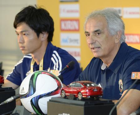 　記者会見するサッカー男子日本代表のハリルホジッチ監督。左は森重＝武漢（共同）