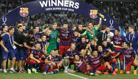 　欧州スーパーカップで優勝し、トロフィーを前に喜ぶバルセロナの選手たち＝トビリシ（ＡＰ＝共同）