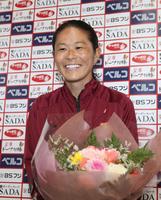 結婚を祝う花束を受け取り笑顔を見せる澤＝神戸市東灘区