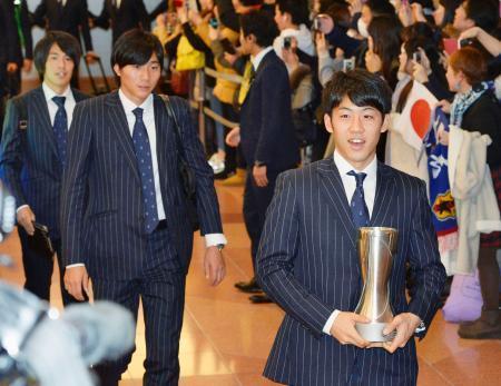　サッカーのアジア選手権で優勝し、笑顔で帰国した遠藤（右）らＵ-２３の日本代表＝３１日夜、羽田空港