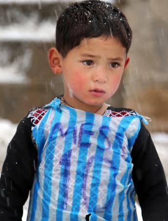 　アフガニスタン・ガズニ州で、ポリ袋で作ったユニホームを着て、サッカーをするムルタザ・アフマディ君＝１月２９日（ＡＰ＝共同）