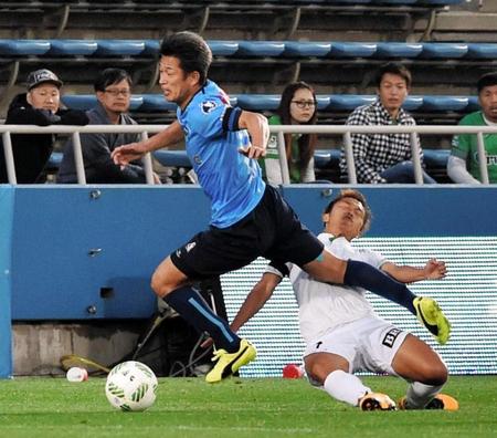 後半、東京Ｖ・杉本竜士（下）と交錯する横浜ＦＣ・三浦知良＝ニッパツ（撮影・佐々木彰尚）