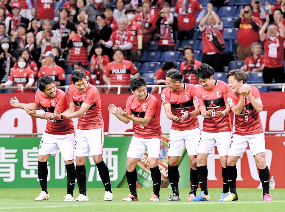 前半、先制ゴールを決め、イレブンとゆりかごダンスをする浦和・宇賀神（右）