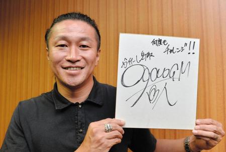 目標を書いた色紙を手に笑顔のガイナーレ鳥取・岡野雅行ＧＭ