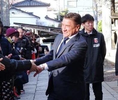 必勝祈願を行った調（つきのみや）神社で、ファンと握手する浦和のペトロビッチ監督