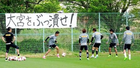 　サポーターが用意した横断幕の前で練習する浦和の選手たち