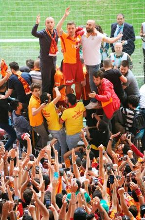 　試合後、観客席で大勢のファンに囲まれるガラタサライのポドルスキ（上中央）＝共同