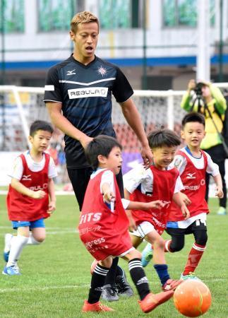 　子どもたちとサッカーをする本田圭佑選手＝１５日、上海（共同）