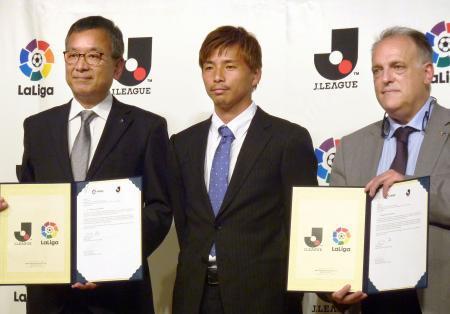 　戦略的連携協定を締結したＪリーグの村井満チェアマン（左）とスペインリーグのハビエル・テバス会長（右）。中央はエイバルの乾貴士＝２２日、東京都内