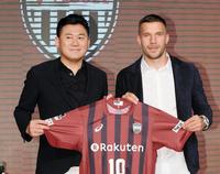 三木谷浩史オーナー（左）とユニホームを持つルーカス・ポドルスキ＝神戸ポートピアホテル（撮影・西岡正）