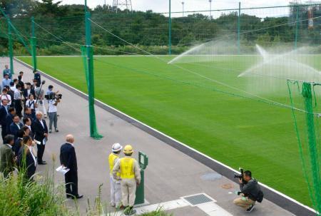 　天然芝が敷かれたＪヴィレッジのグラウンドを視察する日本サッカー協会の理事ら＝１４日、福島県楢葉町