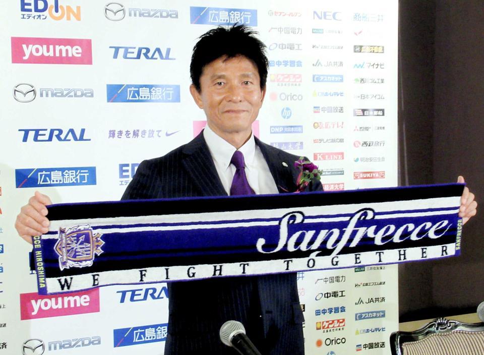 　就任会見でサンフレッチェのマフラーを手にする城福新監督