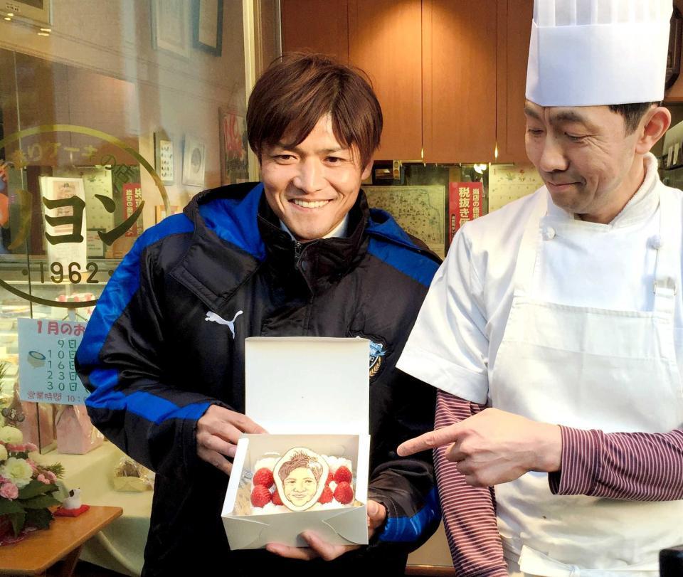 　川崎市内の商店街へのあいさつ回りで、復帰祝いとなる似顔絵入りデコレーションケーキを手にする大久保