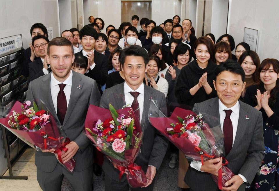 　花束を贈られた神戸の（左から）ポドルスキ、吉田監督、立花社長