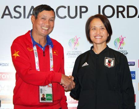 　記者会見でベトナムのチュン監督（左）と握手するサッカー女子日本代表の高倉監督＝６日、アンマン（共同）