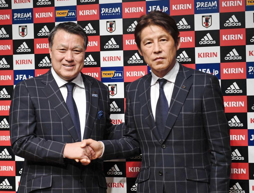 　就任会見を終え田嶋幸三会長（左）と握手を交わす西野朗新監督
