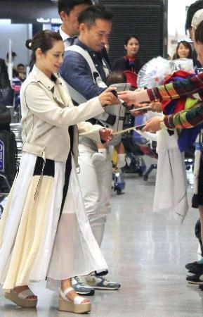 　ファンにサインするサッカーＷ杯日本代表候補の長友と妻で女優の平愛梨さん＝２２日、成田空港