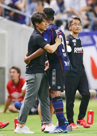 　前半、先制ゴールを決めたファビオ（手前右）を祝福するＧ大阪・宮本監督