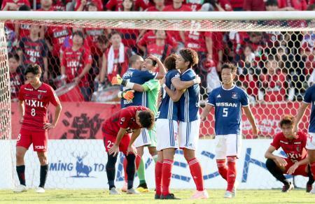 　決勝進出を決め、抱き合って喜ぶ扇原（右から３人目）ら横浜Ｍイレブンと、肩を落とす鹿島イレブン＝ニッパツ球技場