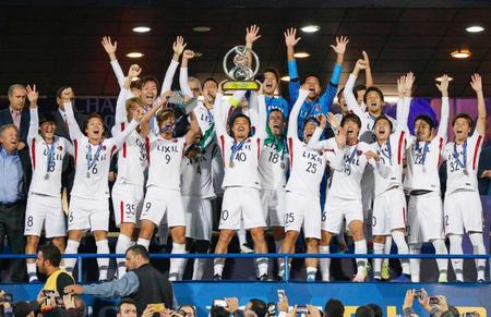 　ＡＣＬを初制覇し、トロフィーを掲げて喜ぶ小笠原（中央）ら鹿島イレブン（共同）