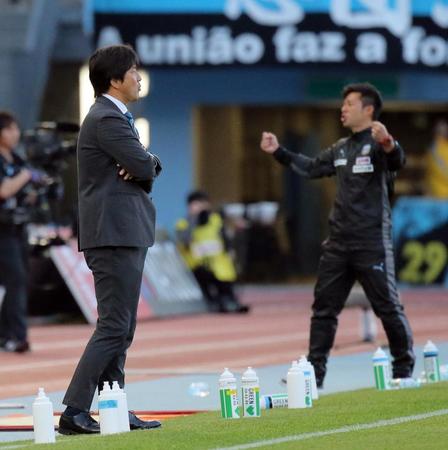 　試合終了の瞬間、ピッチを見つめる磐田・名波監督。右はガッツポーズの川崎・鬼木監督