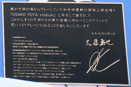 　スタジアムの看板の土台にあしらわれた大迫勇也選手が寄せたメッセージ＝１６日、鹿児島県南さつま市