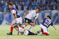 　横浜Ｍ－横浜ＦＣ　前半、相手選手と競り合う横浜ＦＣ・三浦（中央下）と中村（同上）＝ニッパツ球技場