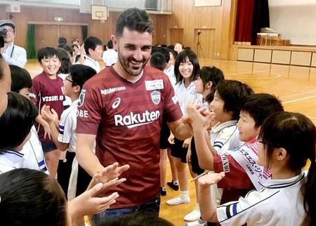 　子供たちとハイタッチをかわすビジャ