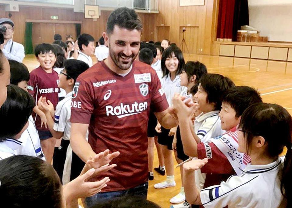 　子供たちとハイタッチをかわすビジャ