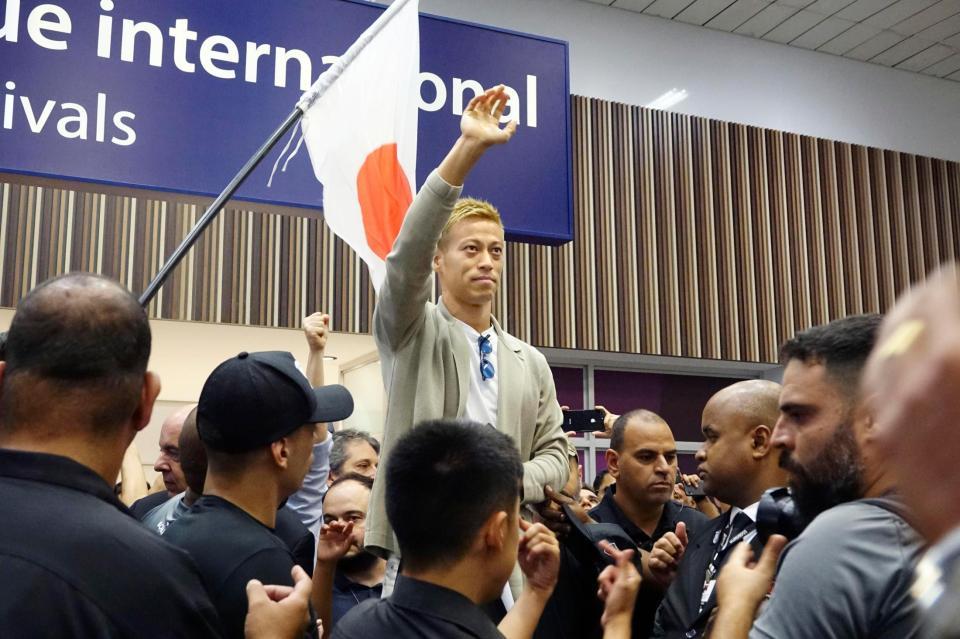 ボタフォゴに加入するためリオデジャネイロの空港に到着し、ファンに手を振るサッカー元日本代表の本田圭佑＝７日（共同）