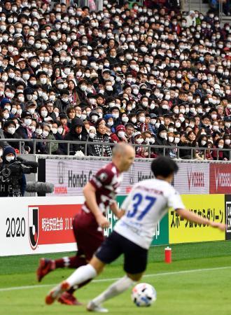 　サッカーＪ１、横浜ＦＣ戦で神戸・イニエスタ（左）らのプレーをマスク姿で観戦する人たち。新型コロナウイルス対策として、歌や肩組みなどの応援行為も禁止された＝２３日午後、神戸市のノエビアスタジアム神戸
