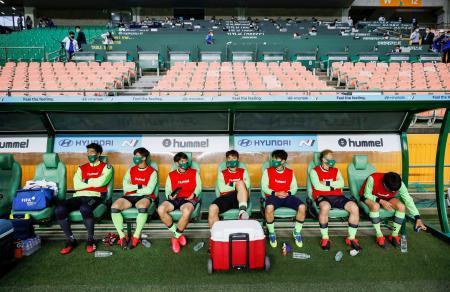 　韓国Ｋリーグ開幕戦の試合前、マスクをしてベンチに座る選手たち＝全州（ロイター＝共同）